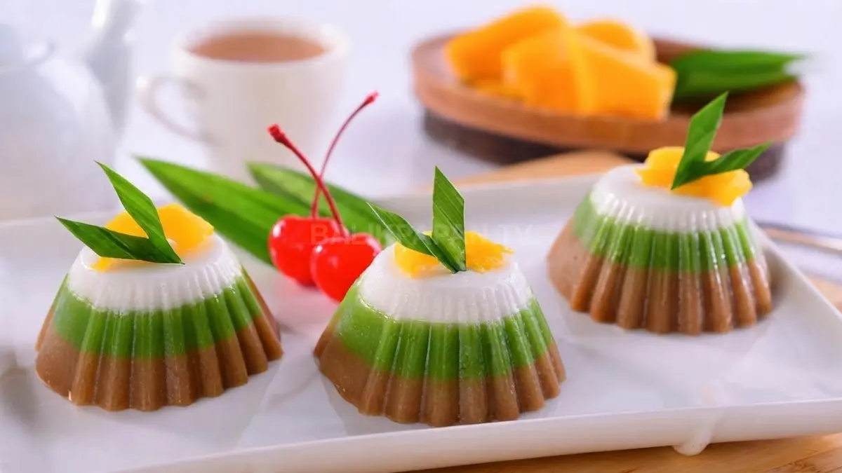 Kue Putri Selat tiga lapis khas Banjar menampilkan warna hijau, cokelat, dan putih dengan tekstur lembut.
