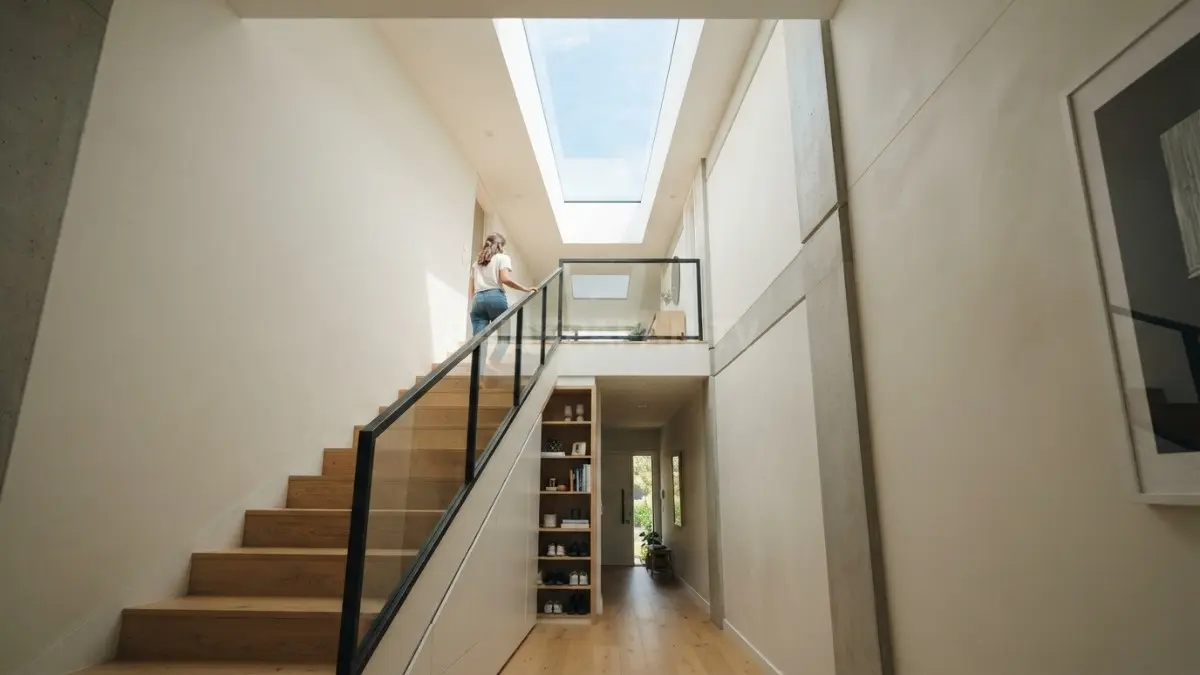 Tangga U memanfaatkan void vertikal, sementara skylight memanjang menerangi area tangga dan ruang penyimpanan bawah tangga. (BTV/AI)