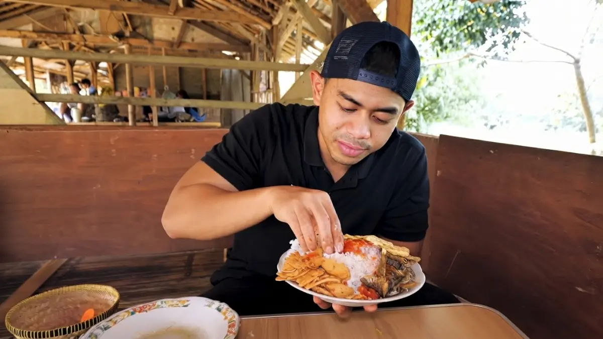 Sambal mentah pedas menjadi pendamping ikan goreng, dilengkapi tempe, bakwan jagung, sayur asem, dan tumisan rumahan. (Sumber: YouTube @tanboykun)