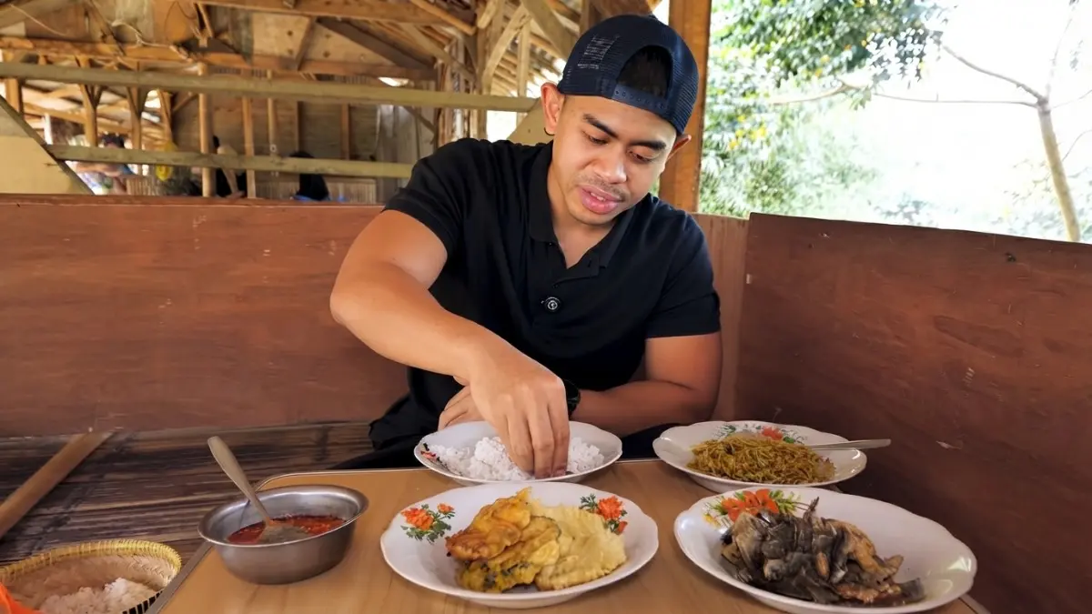 Warung Pecak Jerek Ibu Timi menawarkan ikan goreng garing, sambal mentah pedas, dan suasana saung sederhana. (Sumber: YouTube @tanboykun)