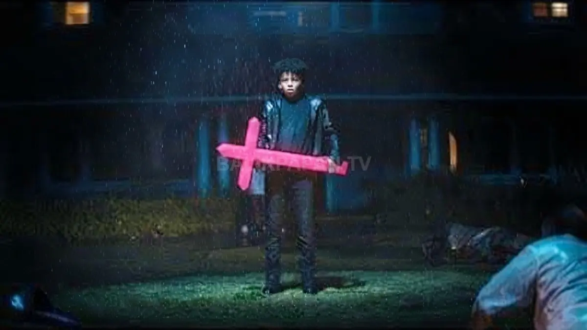 Adegan sinematik The Weeknd memegang salib menyala merah muda di tengah guyuran hujan malam. (BTV/Ai)