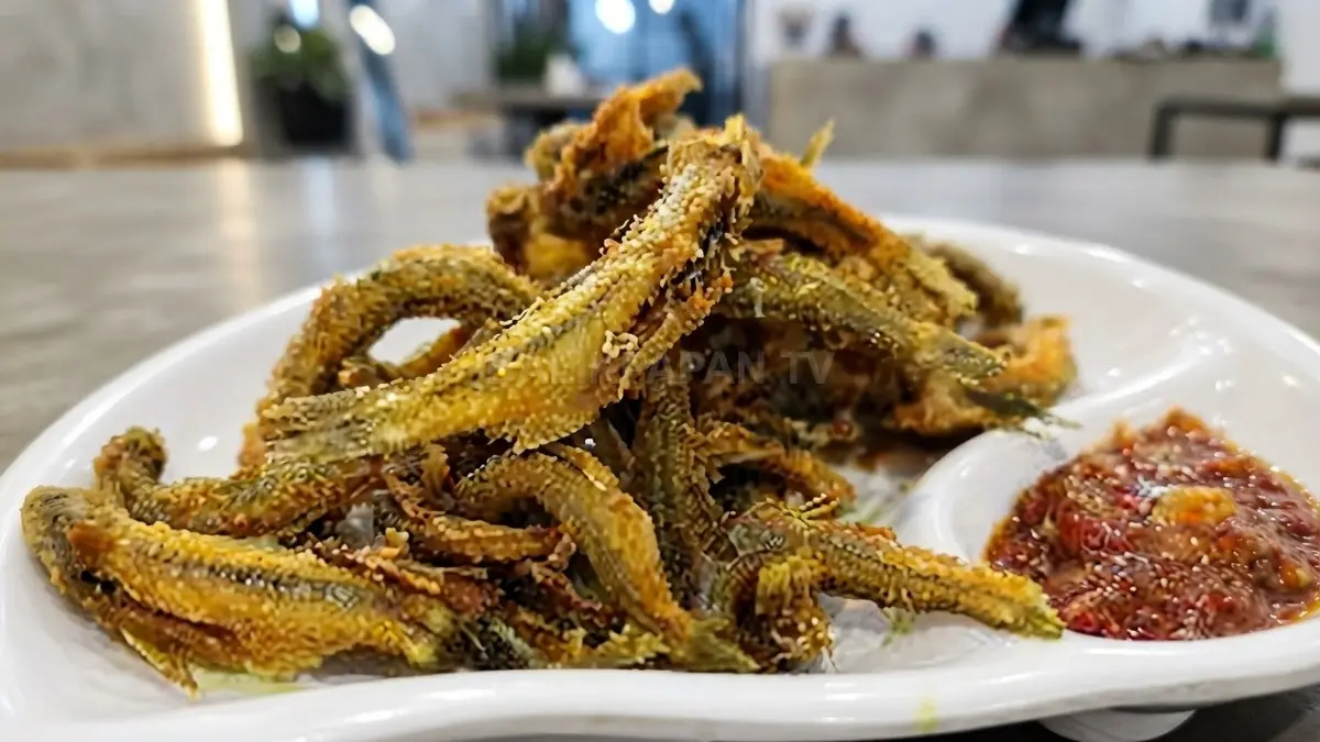 Ikan seluang goreng tersaji renyah dalam piring dengan sambal dan nasi hangat khas kuliner sungai Kalimantan.