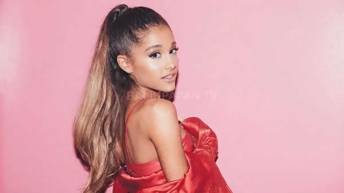 Potret penyanyi Ariana Grande berpose dengan kuncir kuda khasnya berlatar belakang merah muda. (BTV/Ai)