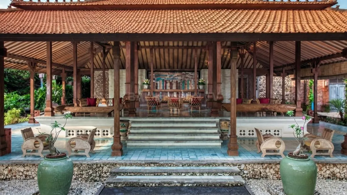 Rumah Joglo menghadirkan atap bertingkat, saka guru, material kayu, dan ruang terbuka yang mencerminkan Jawa. (BTV/AI)
