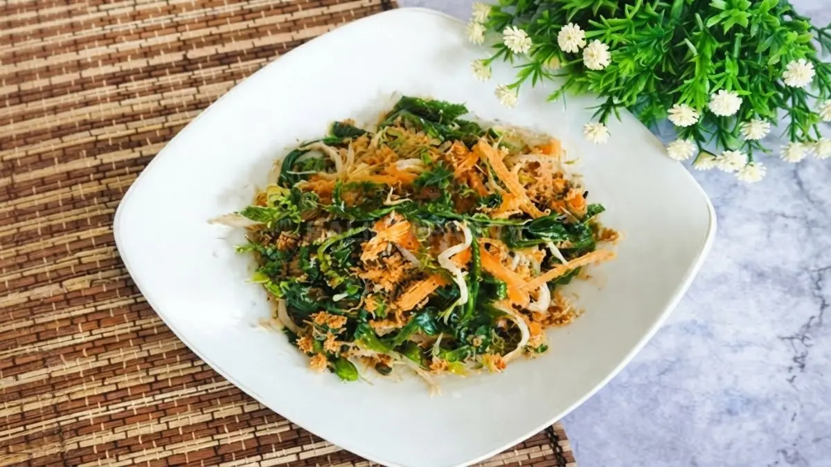 Urap pakis dengan pucuk daun muda, kelapa berbumbu, dan tauge tersaji dalam piring tradisional