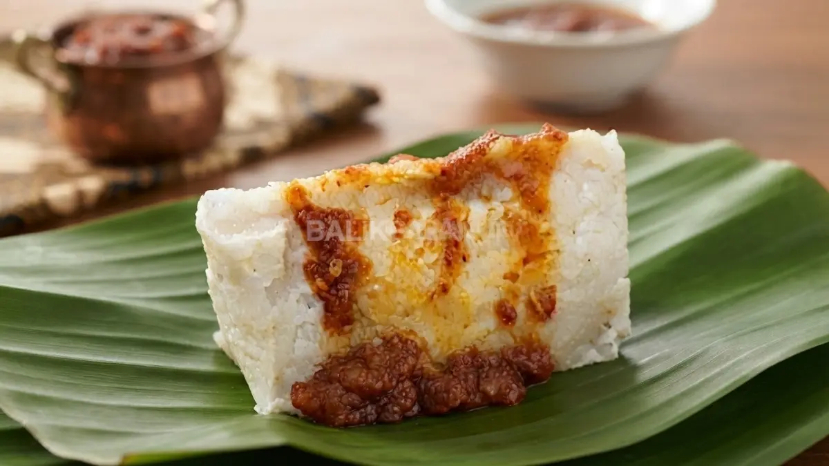 Pundut nasi khas Banjar dibungkus daun pisang dengan sajian santan dan sambal habang.