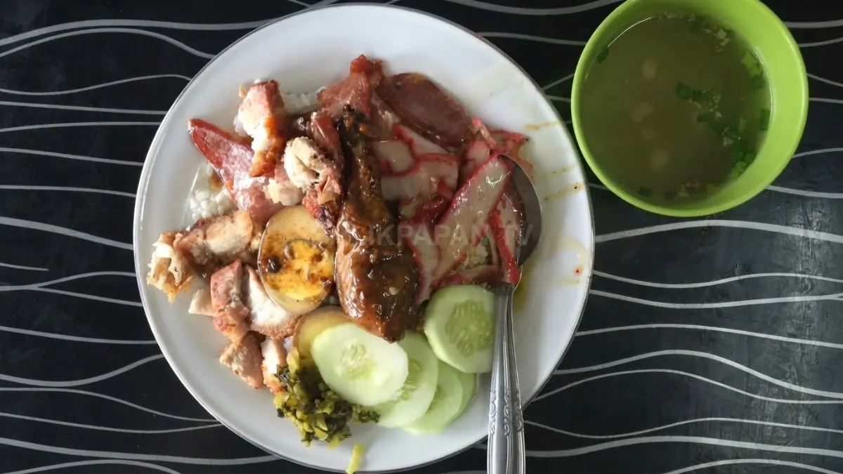 Nasi Ayam Asan Pontianak tersaji dengan ayam, telur, daging, sayuran, dan kuah kental khas.