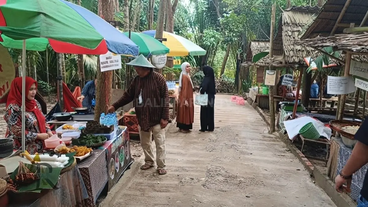 Pedagang mengenakan pakaian tradisional sambil menawarkan jajanan dan hasil kebun kepada pengunjung Pringgondani.