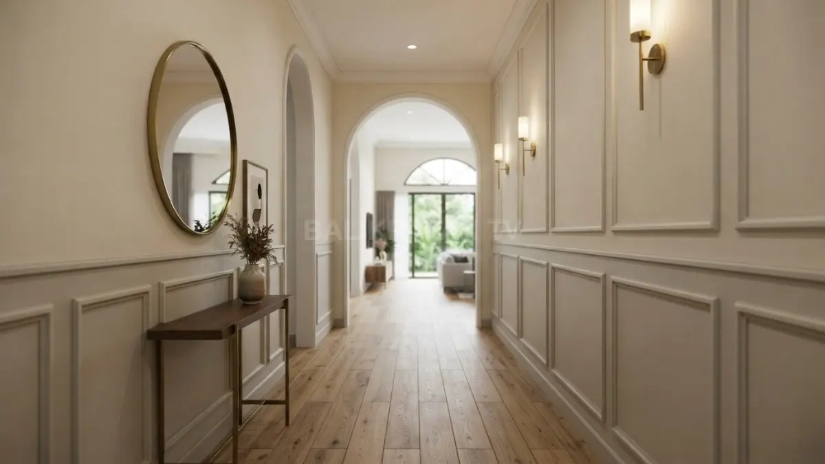 Koridor Transitional dengan panel dinding kotak, lantai kayu, warna krem, dan aksen brass menciptakan suasana elegan hangat. (BTV/AI)