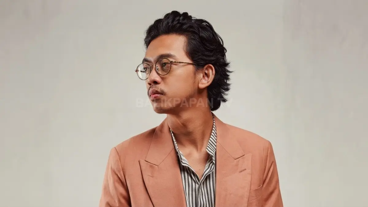 Penampilan musisi Pamungkas dengan gaya khas berjas cokelat dan kacamata bulat. (BTV/Ai)