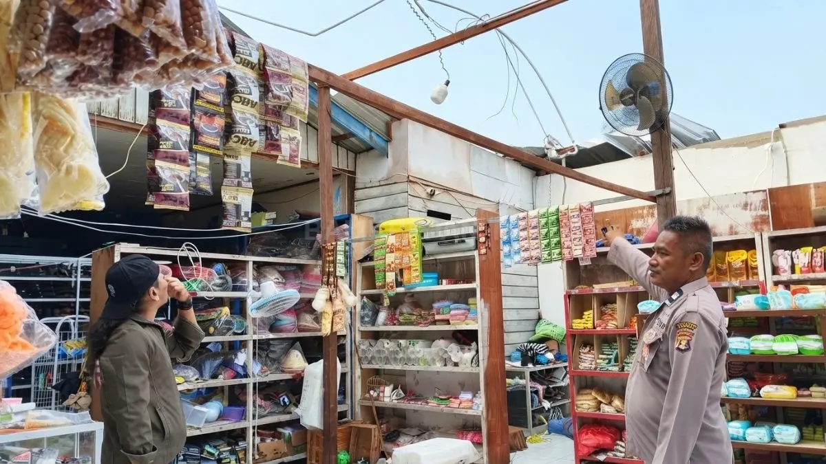 Petugas membantu mengevakuasi barang dagangan dari ruko yang terdampak angin kencang di Sambaliung.