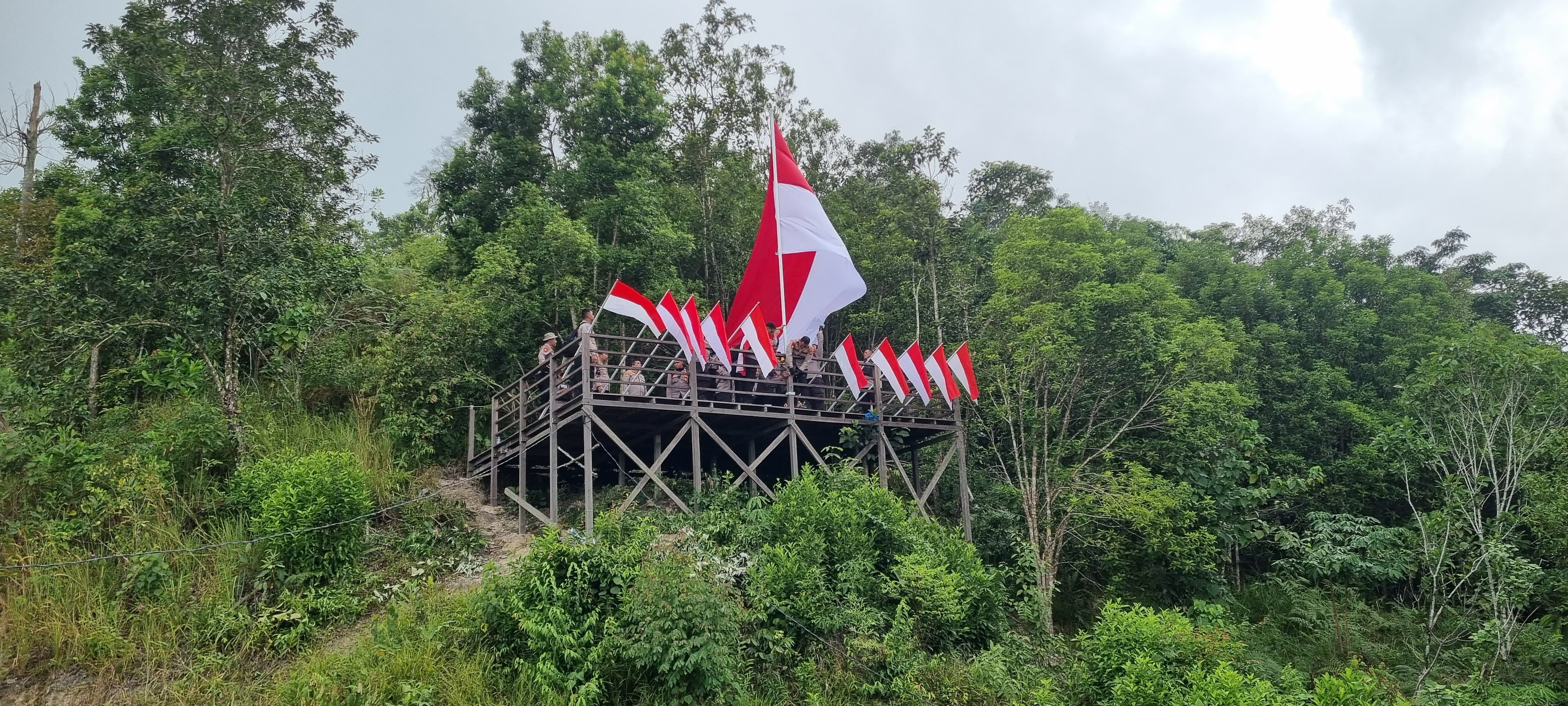 SEMANGAT KEMERDEKAAN: Kapolres Lamandau AKBP Joko Handono pimpin giat pengibaran Bendera Merah Putih di puncak objek wisata Bukit Galugur. HUMAS