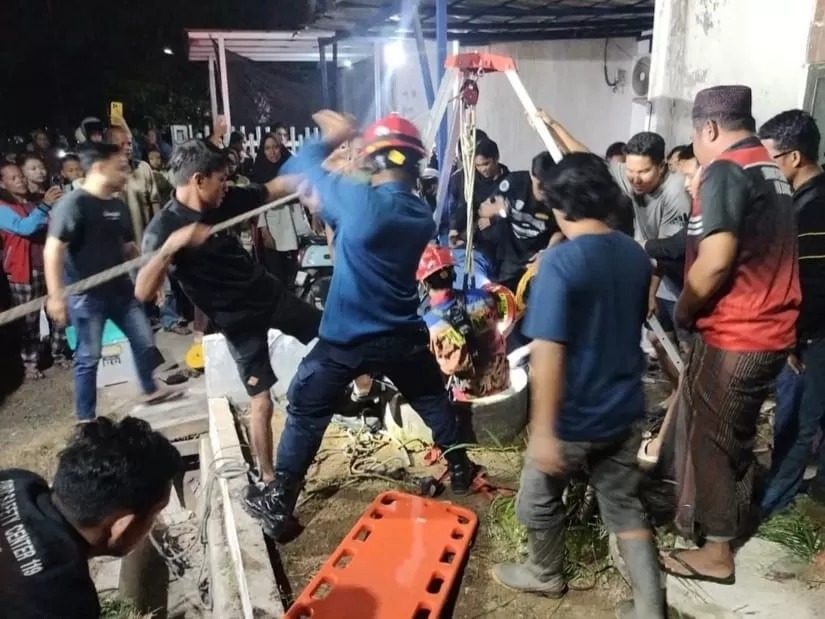 Petugas Damkar menuruni sumur sedalam 12 meter di Desa Tungkaran, Martapura, Kabupaten Banjar untuk mengevakuasi Hamzah (30) dari dalam sumur, Jumat (22/8) malam. Foto: DPKP BANJAR
