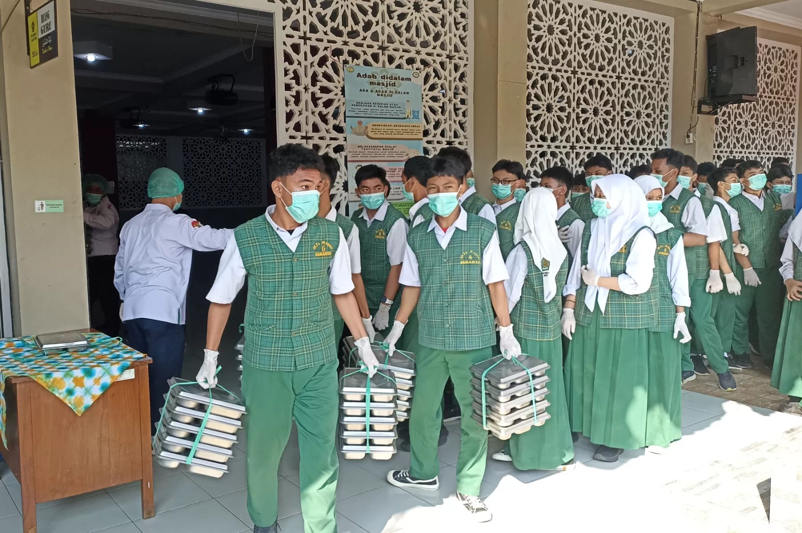 Murid di MTSN 6 Jakarta membagikan Makan Bergizi Gratis (MBG) untuk teman-temannya (26/8). Pembagian MBG dipantau langsung Menteri Agama Nasaruddin Umar. (Hilmi/Jawa Pos)