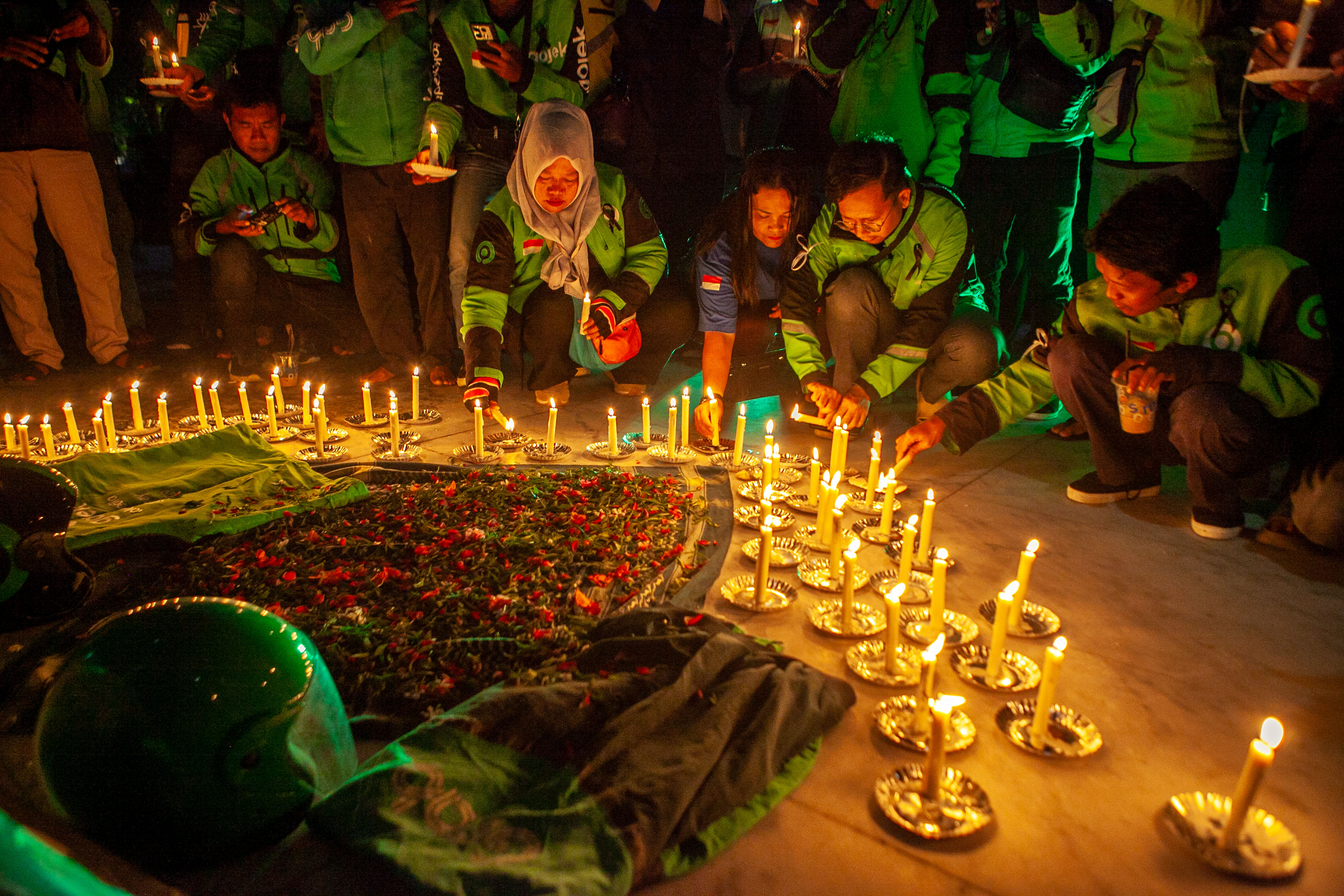 Para driver ojol saat menyalakan lilin, tabur bunga di Tugu Soekarno, Palangka Raya, Kamis malam (4/9/2025). PRATHAMA/KALTENG POS