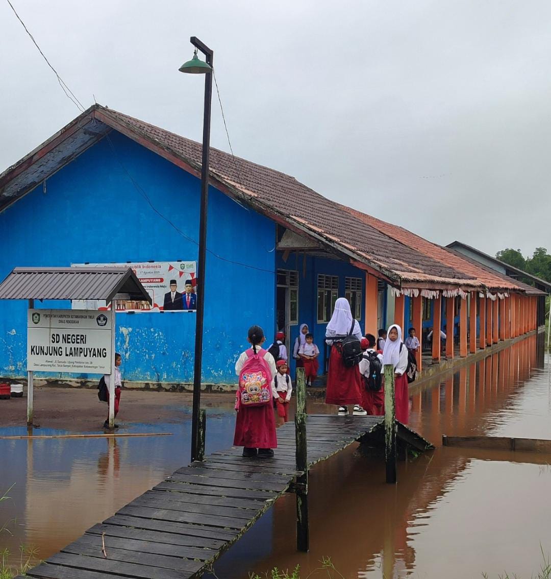 Murid sekolah dasar melintas titian menuju sekolah.BPBD