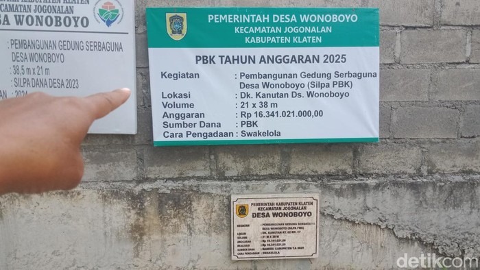 Papan proyek pada gedung yang belum jadi. (detik.com)