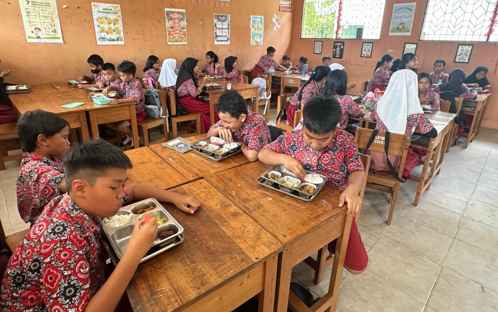 Murid Kelas V SDN 3 Bukit Tunggal lahap dan bahagia saat menyantap MBG, Selasa (30/9/2025). BUDHI SEPRATAMA PUTRA/KALTENG POS