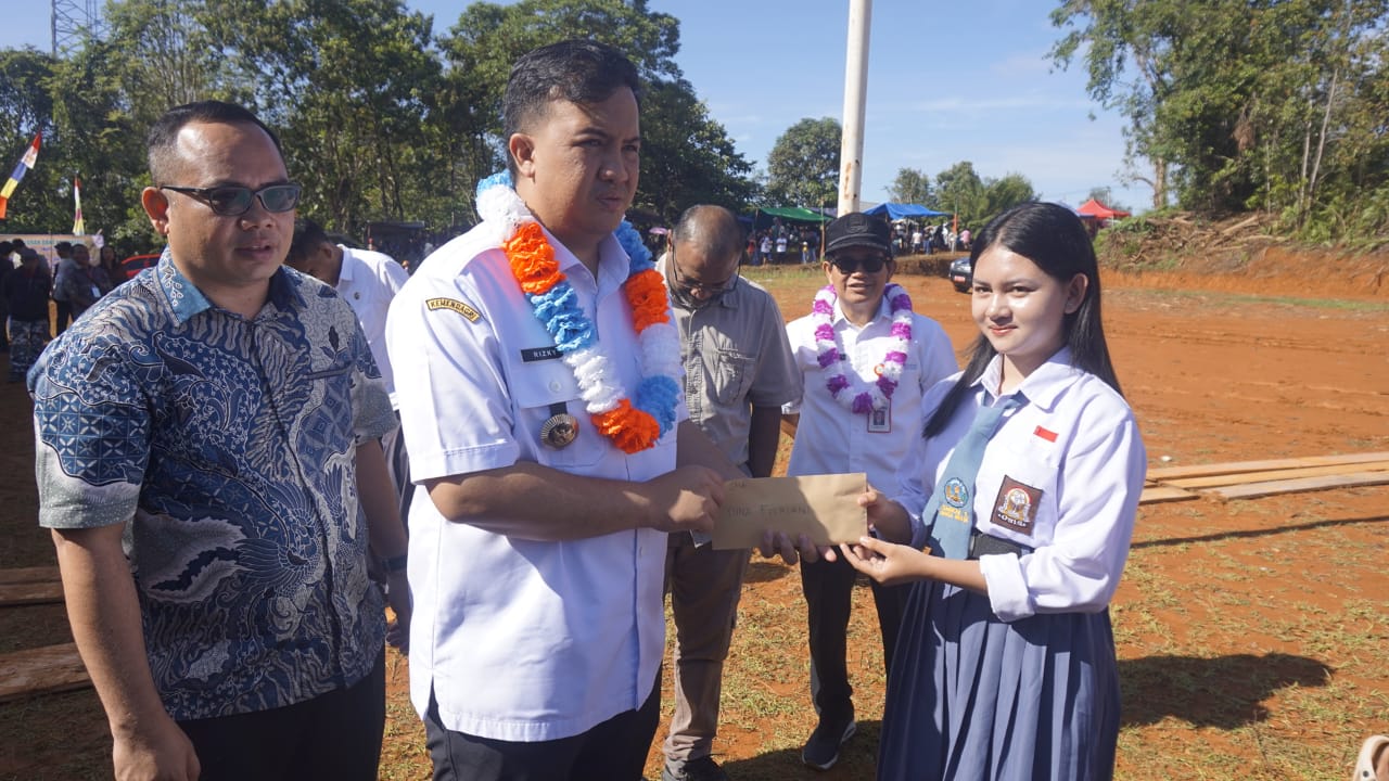 Bupati Lamandau Rizky Aditya Putra, disaksikan Management PT SLR menyerahkan dana kompensasi dari PT SLR kepada warga setempat, Rabu (8/10/2025).RUSLAN/KALTENG POS