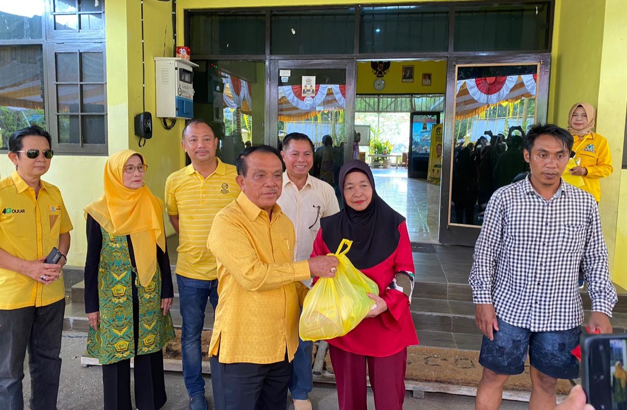 Ketua Dewan Pertimbangan DPD Partai Golkar Kalteng, Ir Abdul Razak menyerahkan paket sembako. SHAFA/KALTENG POS