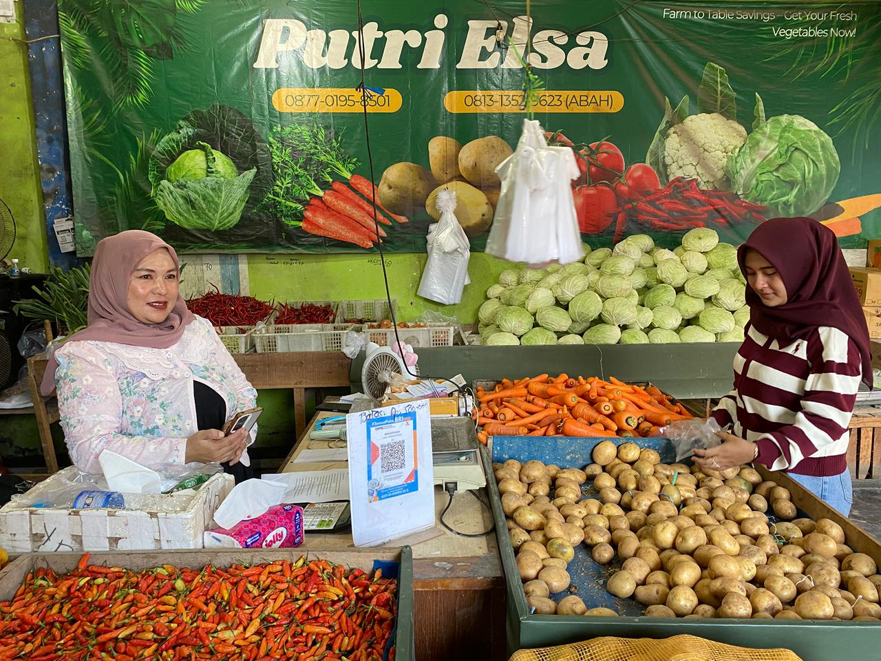 BARCODE: Faidah Masruroh, pedagang Pasar Besar Palangka Raya ketika memperlihatkan QRIS miliknya yang kini jadi alternatif transaksi jual beli dan BRI Merchant. (GILANG/KALTENG POS)