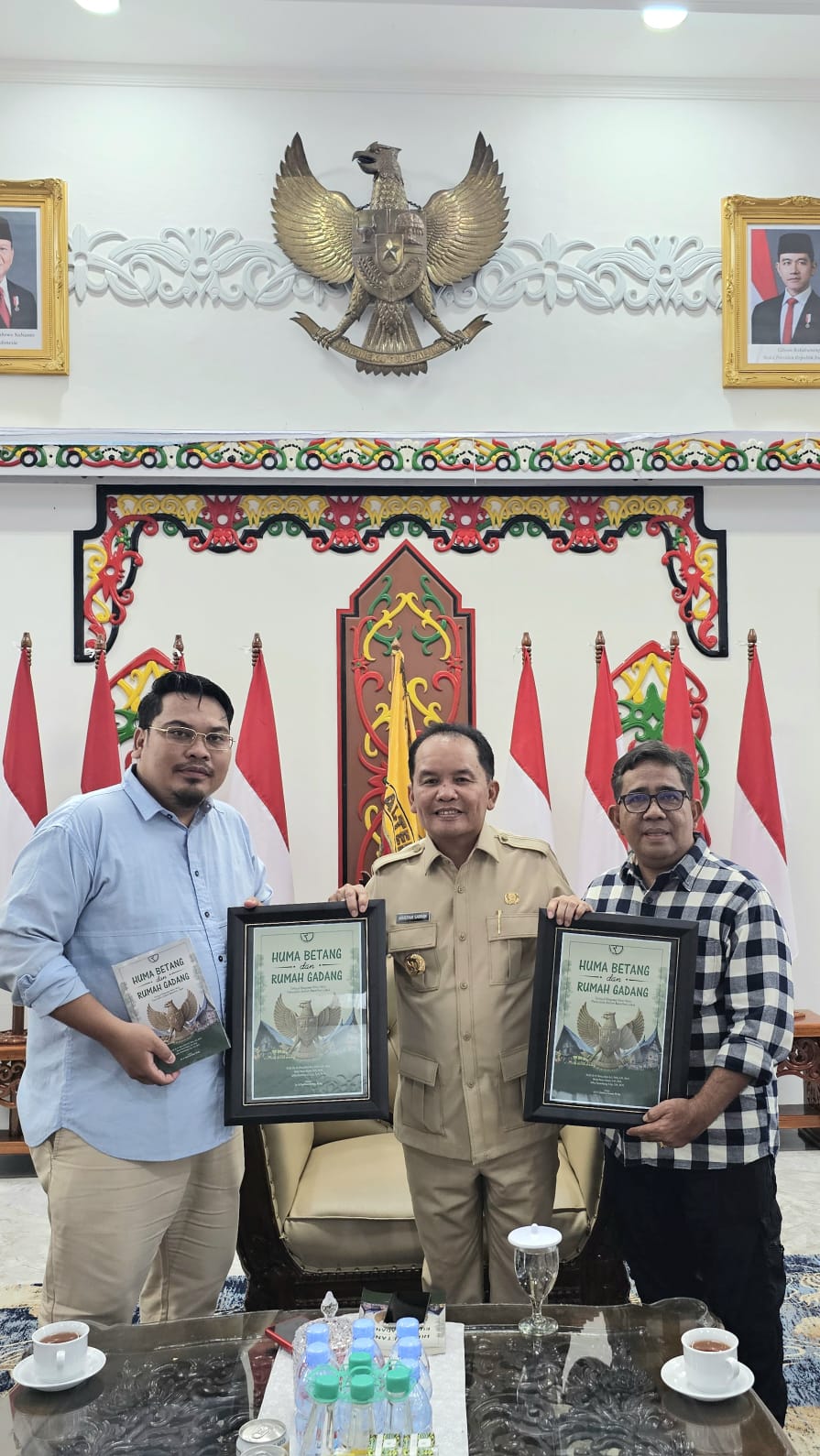 LITERASI: Gubernur Kalteng H. Agustiar Sabran (tengah) menerima buku "Huma Betang dan Rumah Gadang" dari Prof Ibnu Elmi A.S. Pelu dan Jefry Tarantang, di Istana Isen Mulang, Minggu (2/11/2025).