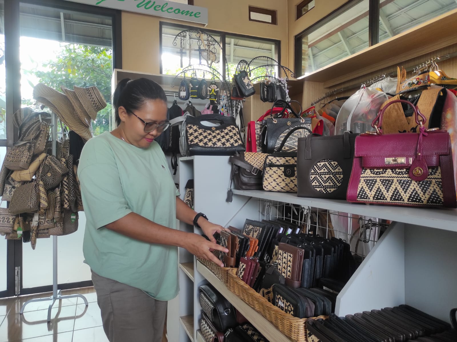 Owner Indang Apang Galeri, Amelia Agustina menyusun produk kerajinan di galeri miliknya. (ANISA B WAHDAH/KALTENG POS)
