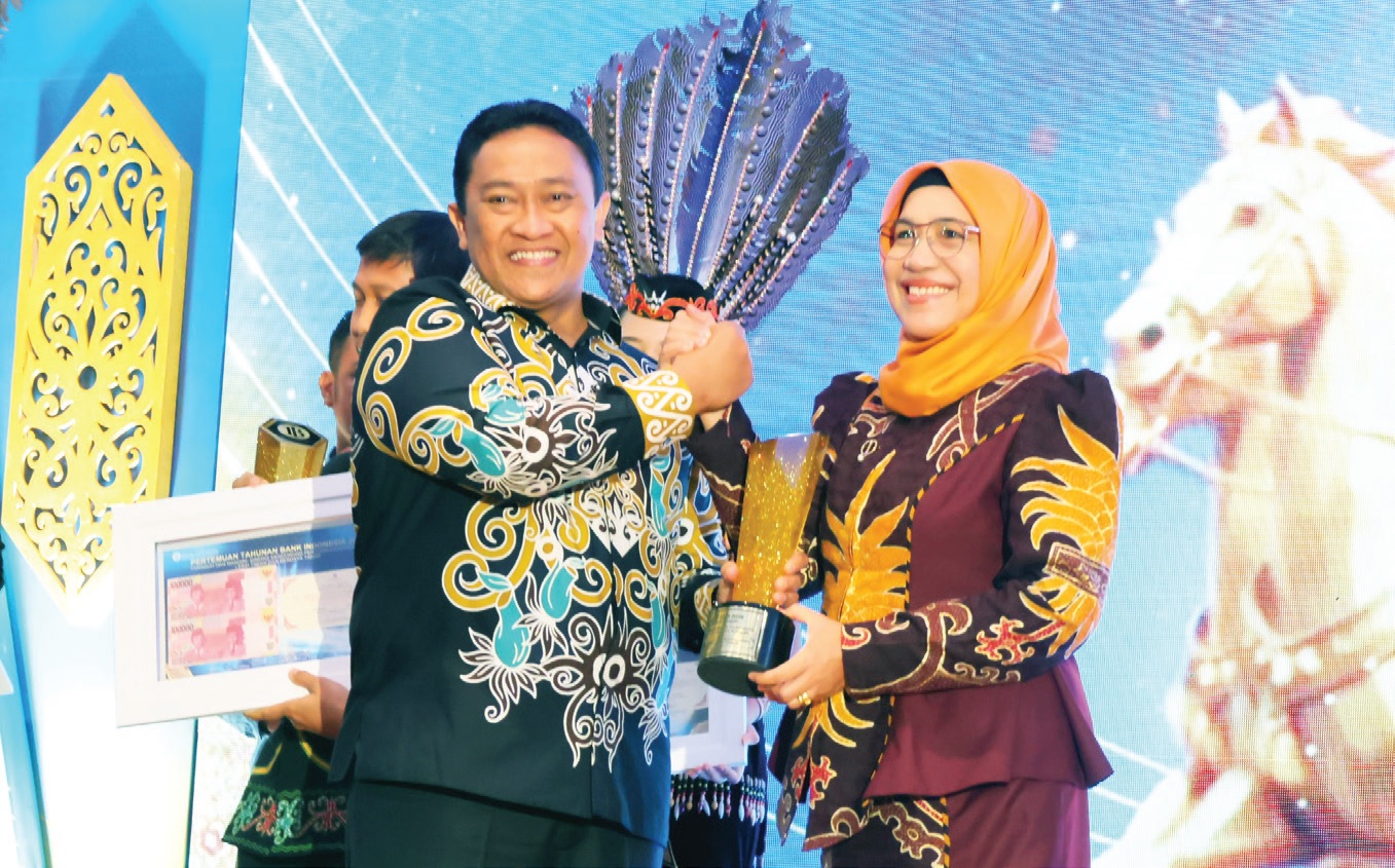 PRESTASI: Kepala Disdagperin Kalteng Norhani menerima penghargaan sebagai mitra strategis BI yang diserahkan oleh Wagub Kalteng H Edy Pratowo di Aula Betang Hapakat Kantor Perwakilan BI.