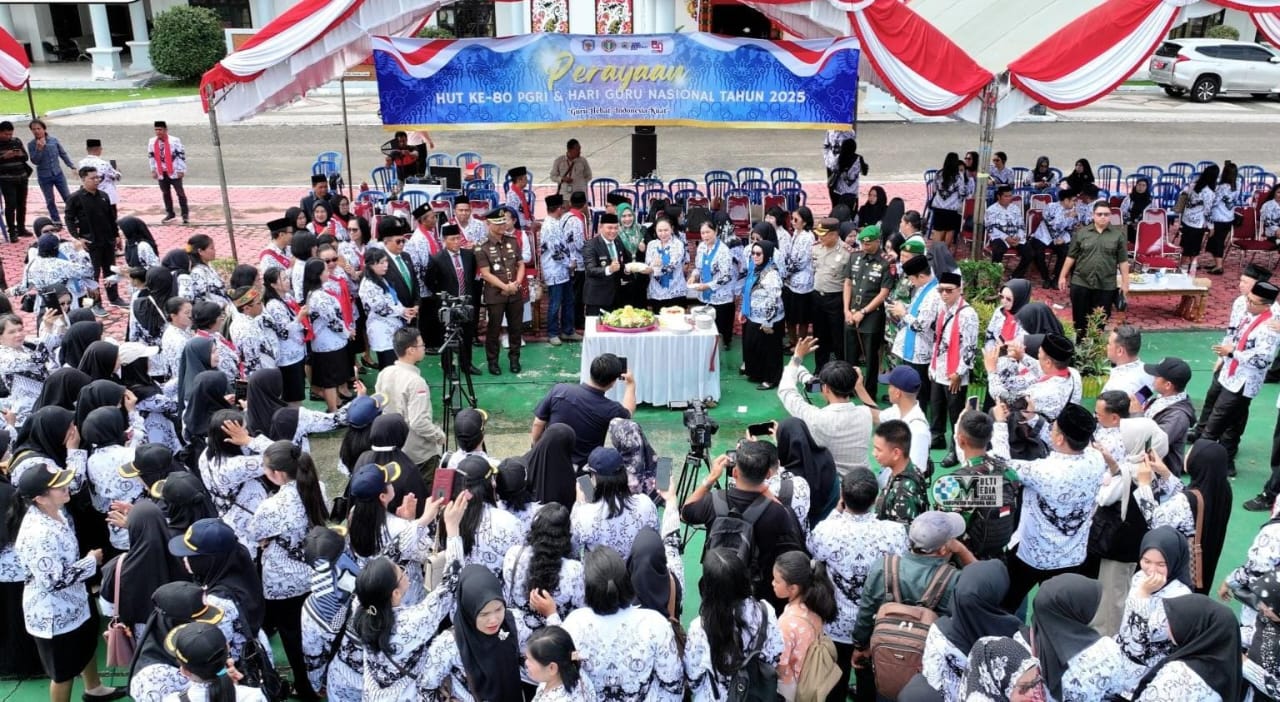 Wakil Bupati Murung Raya menyerahkan tumpengan kepada salah satu Guru saat melaksanalan upacara HGN.HUMAS