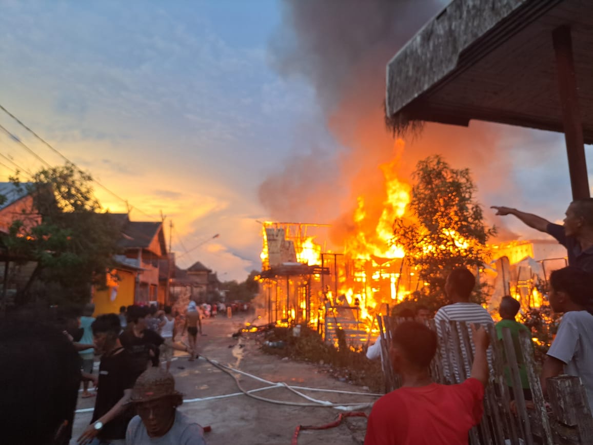 Petugas Damkar bersama warga melakukan pemadaman kebakaran rumah