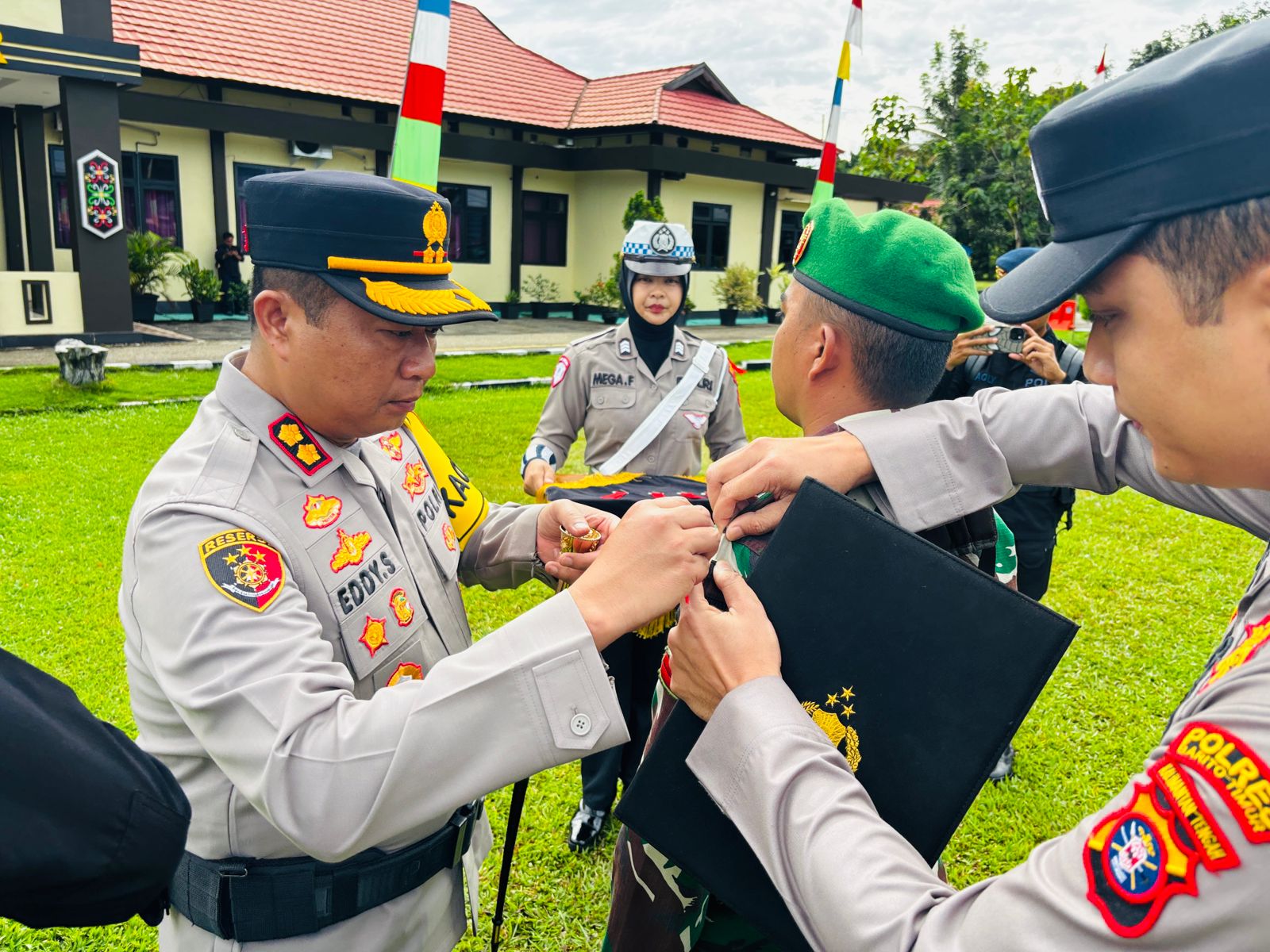 Kapolres Bartim Edi Susanto ketika melakukan pemasangan pita tanda dimulainya Apel Gelar Pasukan Operasi Lilin Telabang 2025.HUMAS