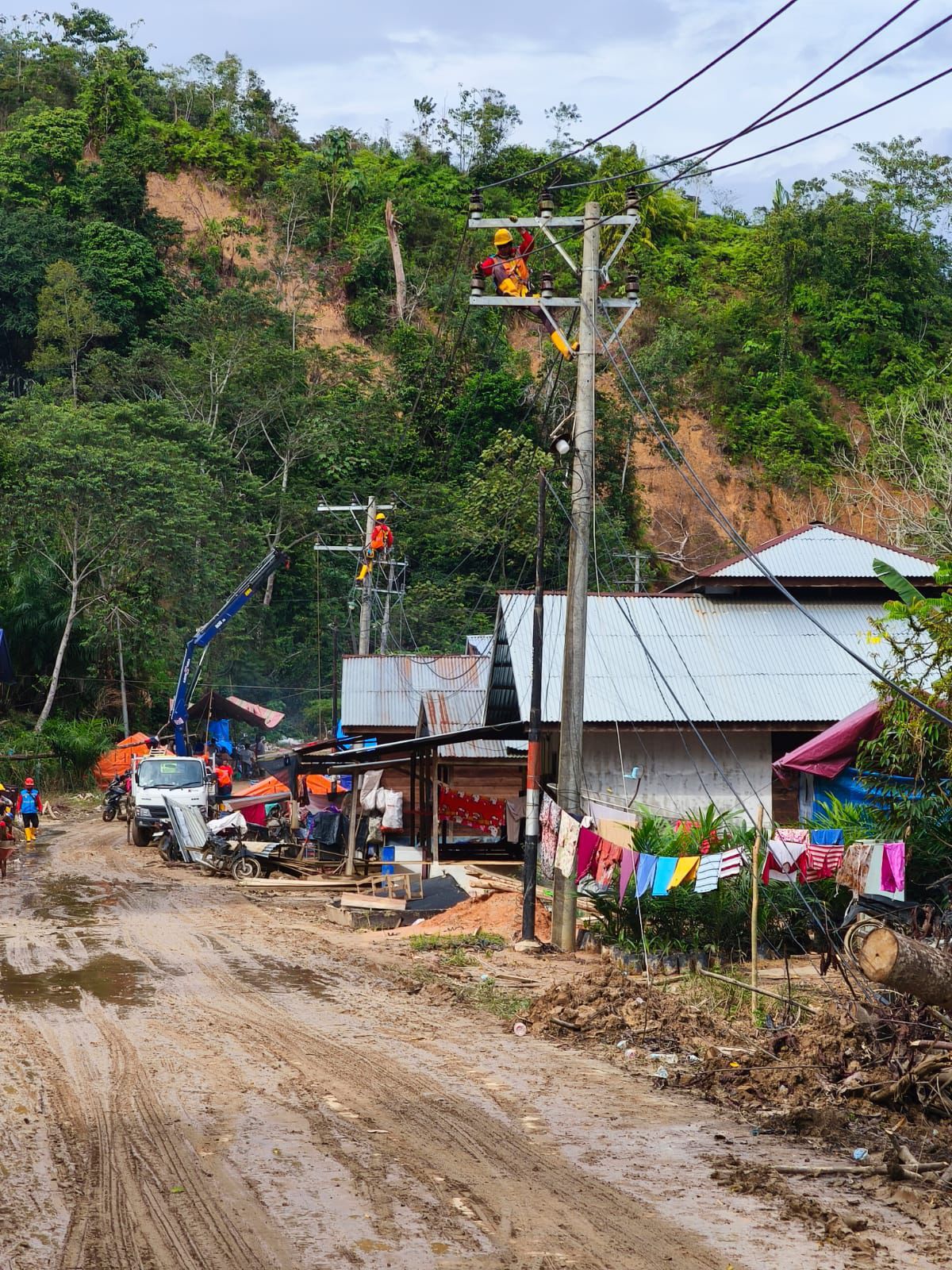 Petugas PLN sedang memperbaiki konstruksi jaringan listrik di Desa Lubuk Sibuk, Kuala Simpang, Aceh Tamiang.  (PLN)