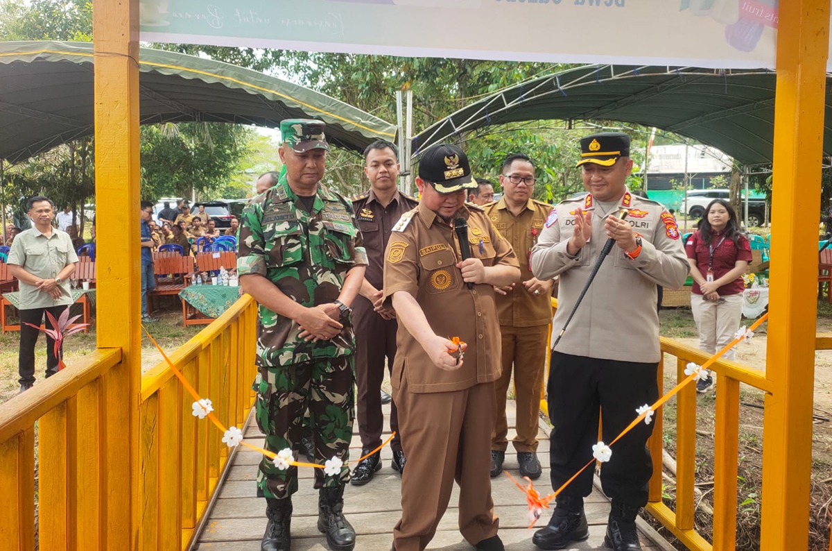 Bupati Katingan Saiful menguntingkan pita sebagai tanda dibukanya untuk umum kolam pemancingan yang ada di Kebun Raya Katingan, Senin (26/1/2026). JERI / KALTENG POS