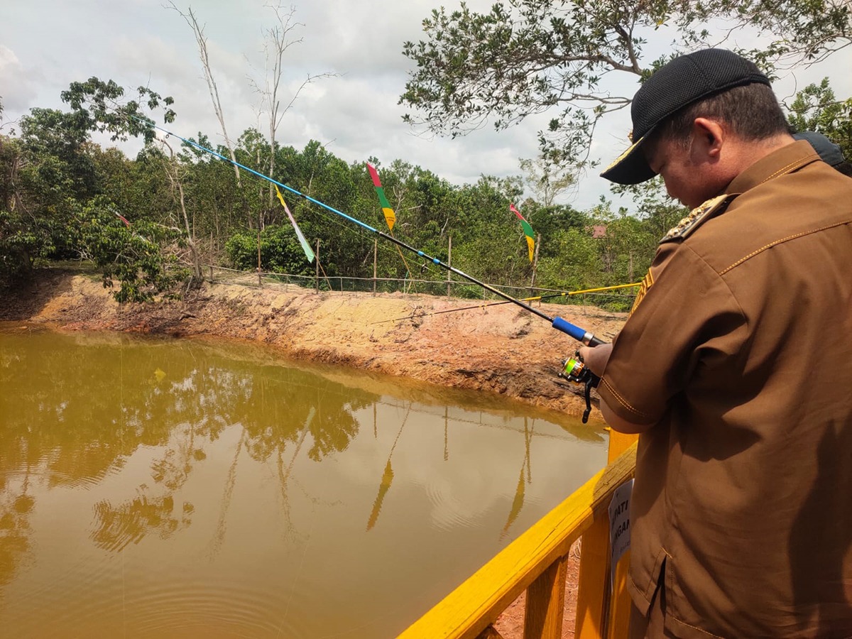 Bupati Katingan Saiful, ketika memancing ikan di kolam yang baru dibuka di Kebun Raya Katingan, beberapa waktu lalu. JERI/ KALTENG POS