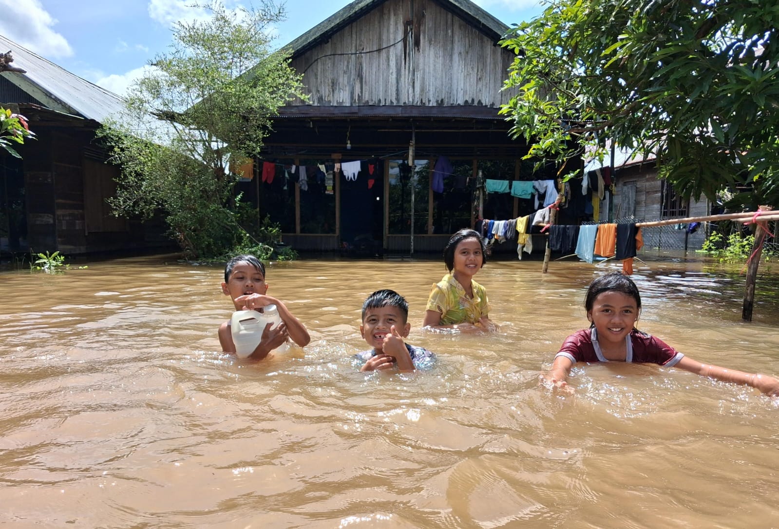 Anak-anak bermain di halaman yang banjir. AGUS PRAMONO/KALTENGPOS.JAWAPOS.COM