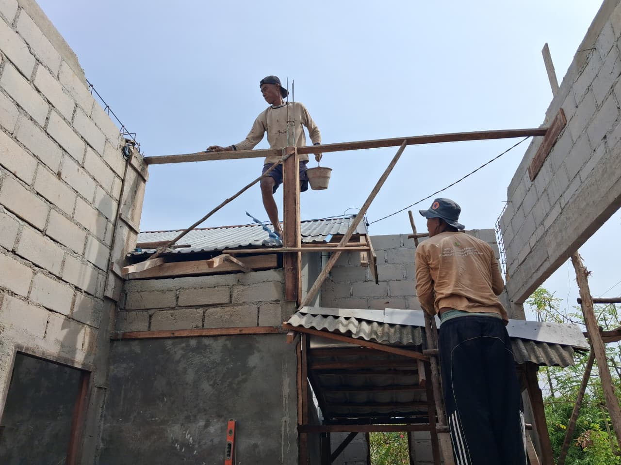 Dua pekerja melakukan proses pembangunan dapur KPR.
