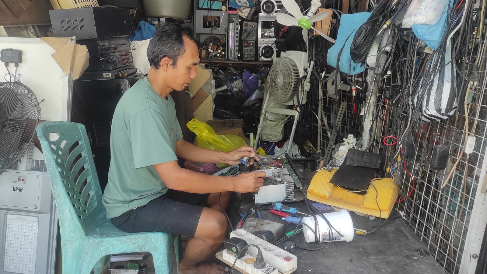 Ayon Harianto saat memperbaiki barang elektronik milik pelanggan di Toko Pelangi Elektronik, Jalan Sultan Hasanudin Palangka Raya, Sabtu (14/2/2026). ANISA/KALTENG POS