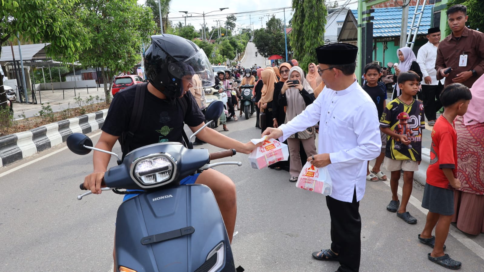 Kepala Kemenag Barito Utara, H. Arbaja saat membagikan takjil kepada pengendara disekitar kantor Kemenag Barito Utara.KEMENAG 
