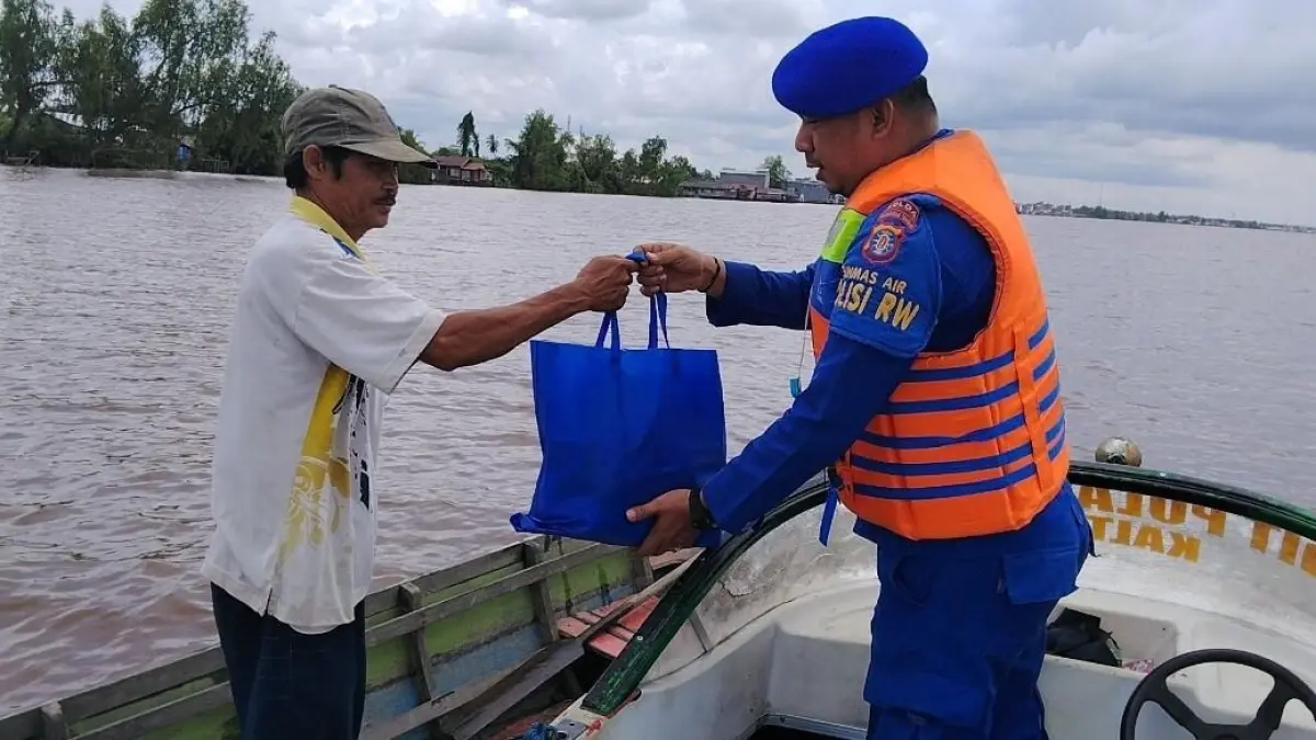 Personel Ditpolairud Polda Kalteng menyalurkan bantuan sembako kepada warga. HUMAS
