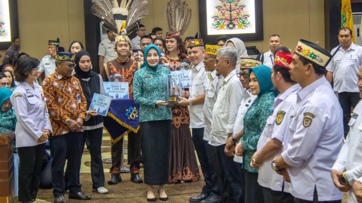 Ketua TP PKK Kalteng Aisyah Thisia Agustiar Sabran memberikan piala kepada Bupati Gunung Mas Jaya S Monong. Arief Prathama/Kalteng Pos