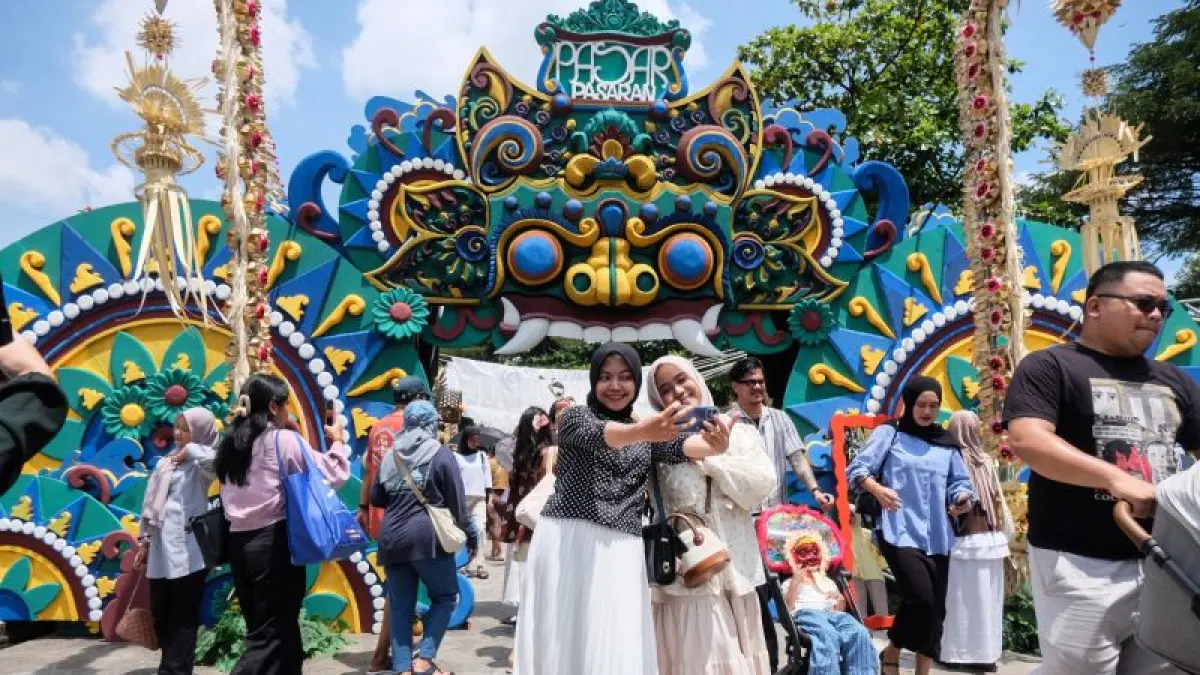 Berwisata jadi pilihan kaum muda sekarang untuk menikmati hidup nyaman. Tampak wisatawan berswafoto dengan latar dekorasi seni di Taman Balekambang, Solo, Jawa Tengah, Sabtu (11/4/2026).  (ANTARAFOTO/Maulana Surya)