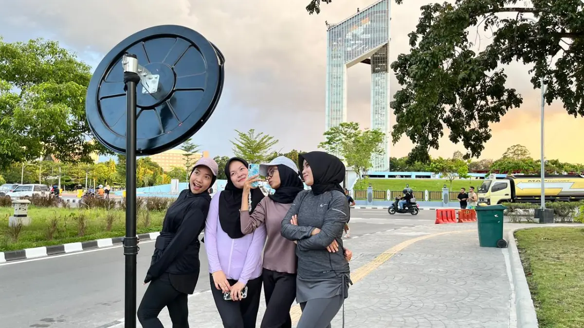 Pengunjung spot foto kaca cembung dengan background Bundaran Besar. AYU/KALTENGPOS.JAWAPOS.COM