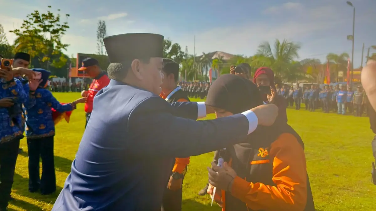 Bupati Kotim, Halikinnor mengalungkan tanda pengenal kepada petugas sensus yang akan bertugas.(Miftah/kaltengpos.jawapos.com)