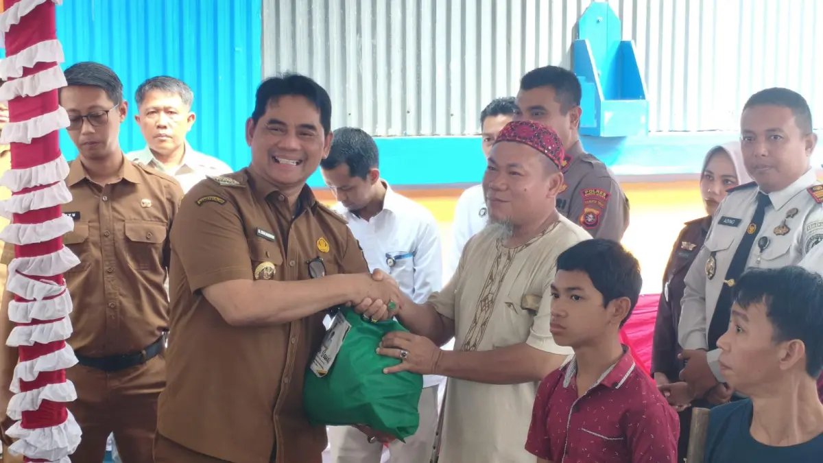 Bupati Barito Utara H Shalahuddin secara simbolis memberikan bantuan sosial kepada salah satu penerima.(Reno/Kalteng Pos)