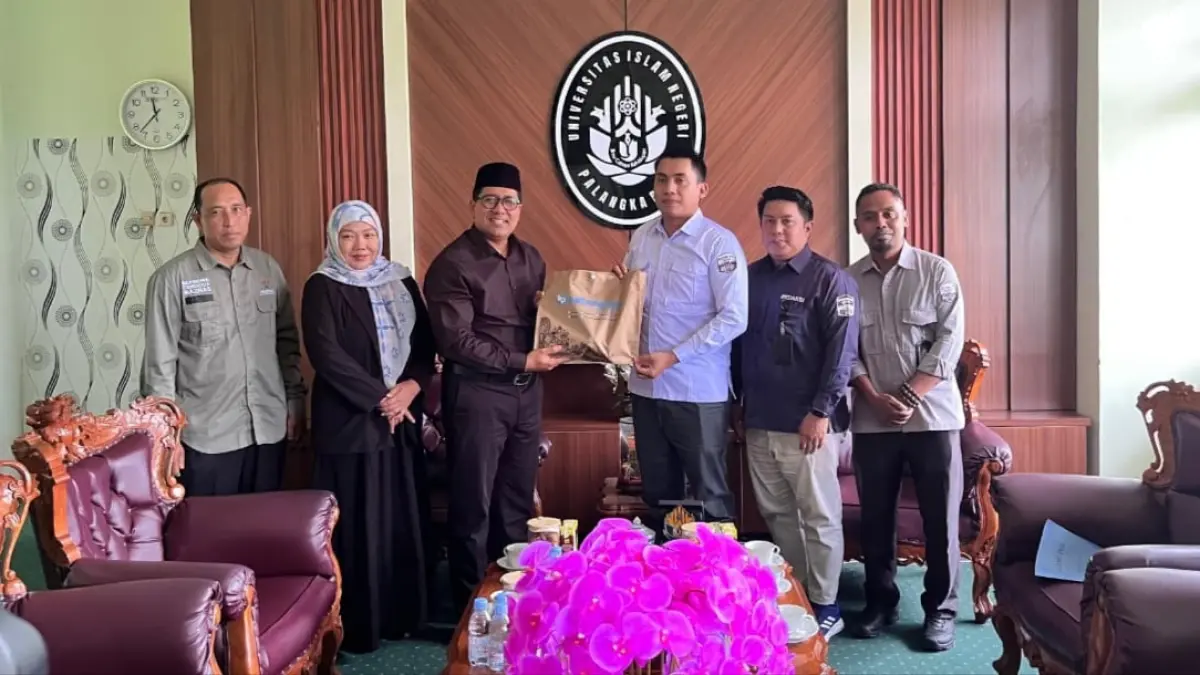 Rektor UIN Palangka Raya Prof Dr H Ahmad Dakhoir menerima souvening dari Pimred Kalteng Husrin A Latief, saat silaturahmi. FOTO KALTENG POS