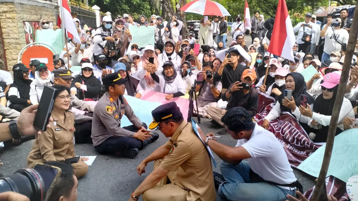 Gubernur Kalteng Agustiar Sabran memberikan punggungnya untuk Korlap Aksi, Tirta Yoga Panuntun untuk menandatangani kertas yang berisi aspirasi, Selasa (30/6/2026). ISMAIL/KALTENGPOS.JAWAPOS.COM