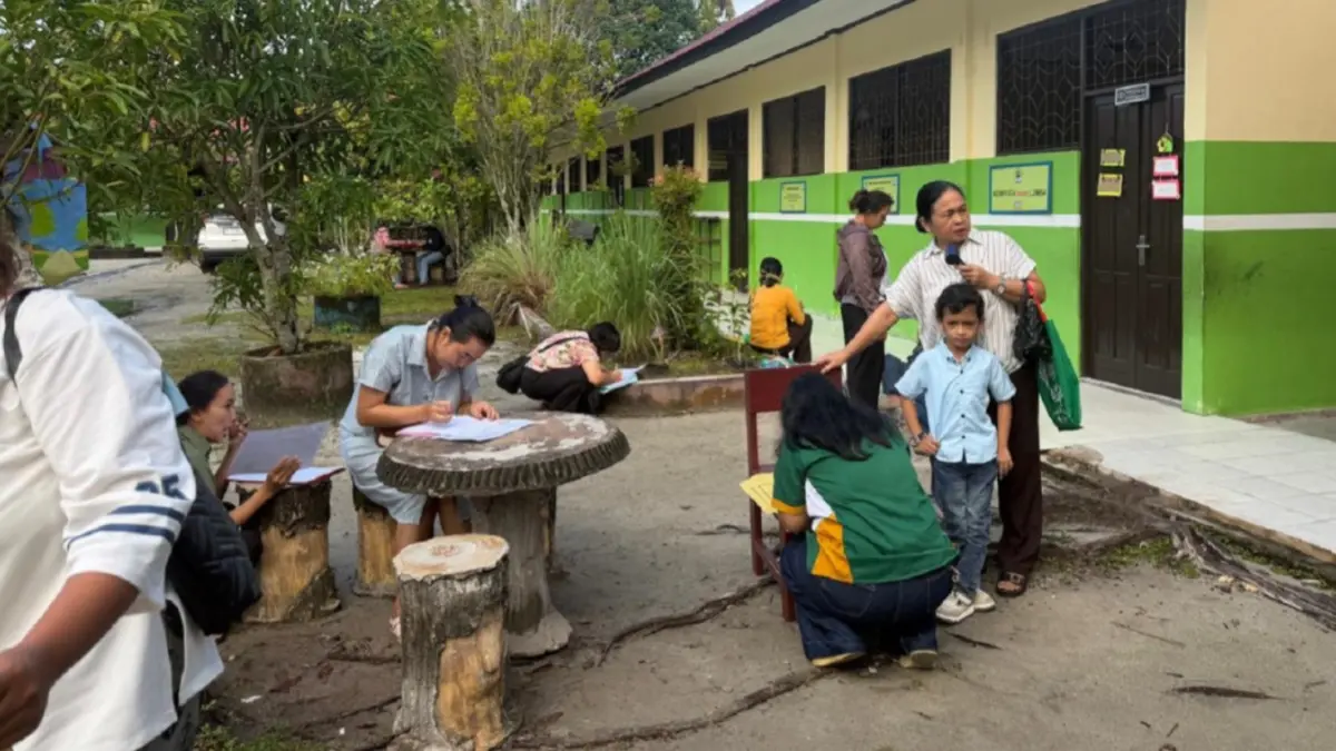 Orang tua calon murid sedang mengisi formulir pendaftaran sekolah di halaman SDN 5 Menteng.(Dhea/Kalteng Pos)