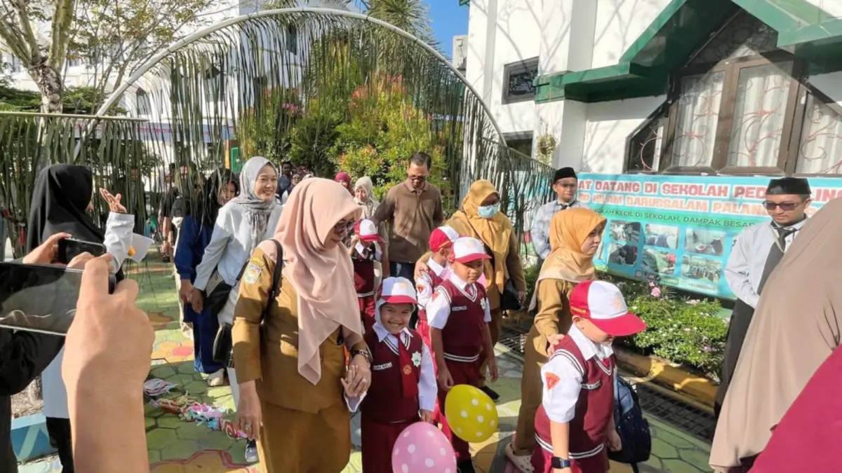 Orang tua mengantarkan anaknya melewati gerbang lawang sakepeng sebagai simbol serah terima peserta didik baru pada kegiatan MPLS SDIT Darussalam Palangka Raya, Senin (13/7). Ayu/kaltengpos.jawapos.com