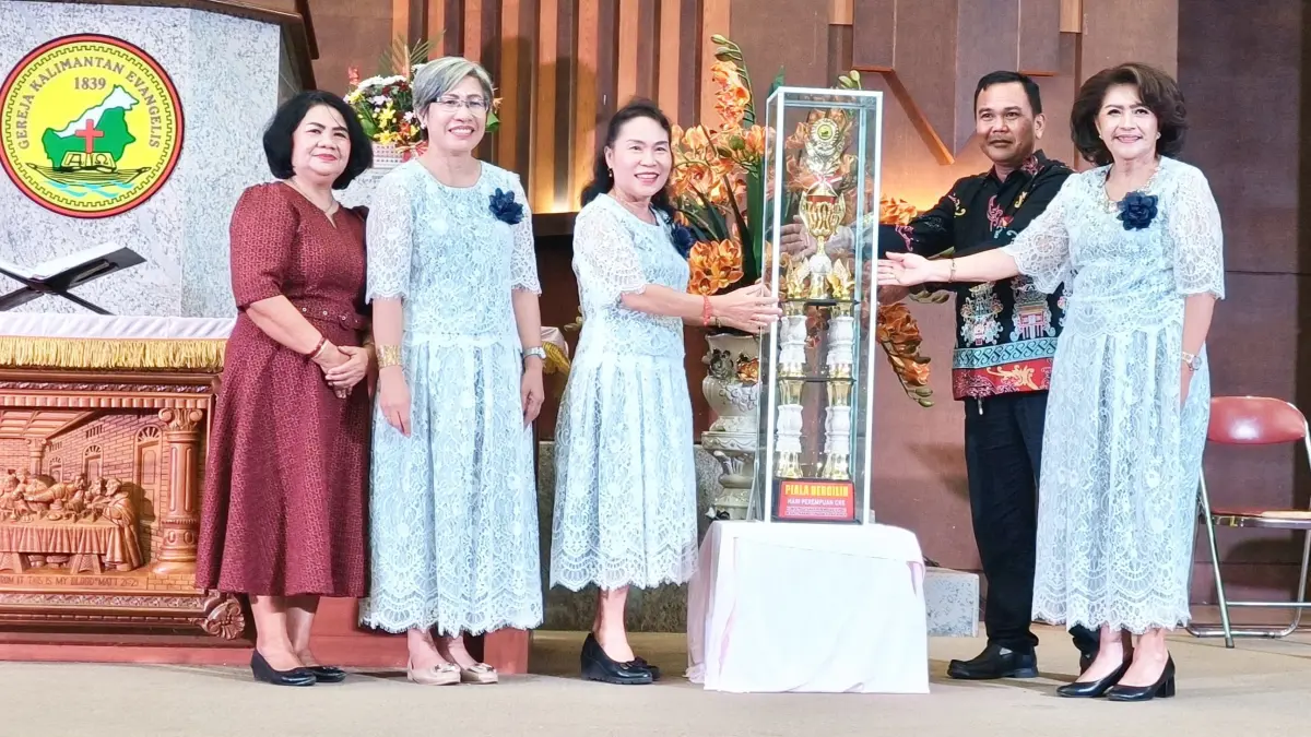 Ketua KPPer P.Raya Hilir, Yulinda Lampe (kanan) saat menyerahkan piala kepada perwakilan SPPer Panarung didampingi Ketua Majelis Resort GKE Pahandut P.Raya Hilir Pdt. Cucue Meiyadie MTh (dua kanan) dan ketua Panitia, Pnt. Isa Ariayini (dua kiri).(Iyan/Kalteng Pos)