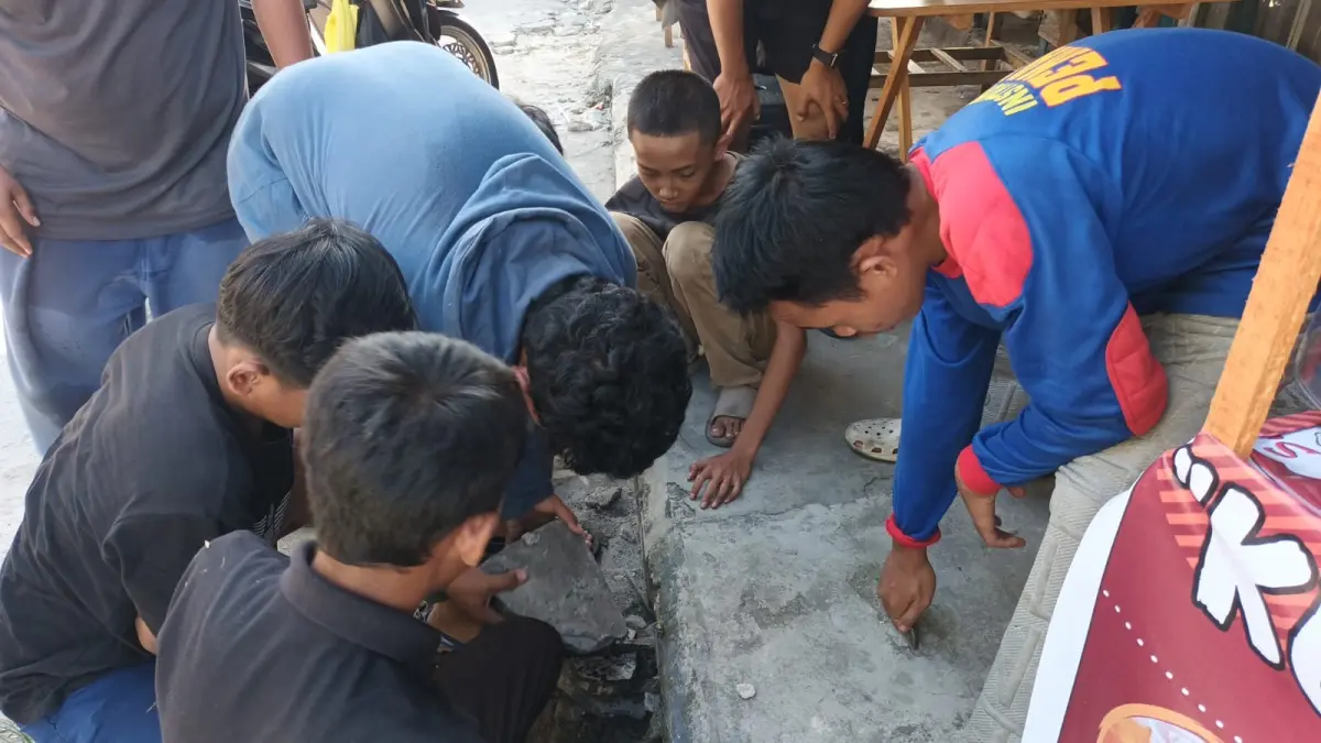 Evakuasi handphone terjatuh di sela-sela beton drainase.(BPK Kamboja)
